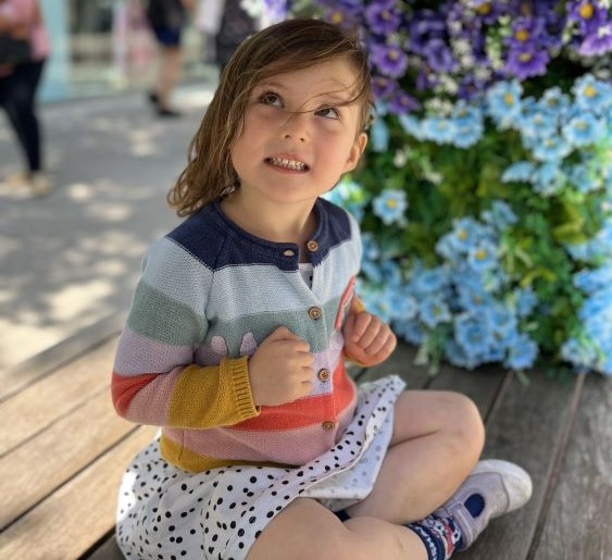 Little girl looking up at flowers