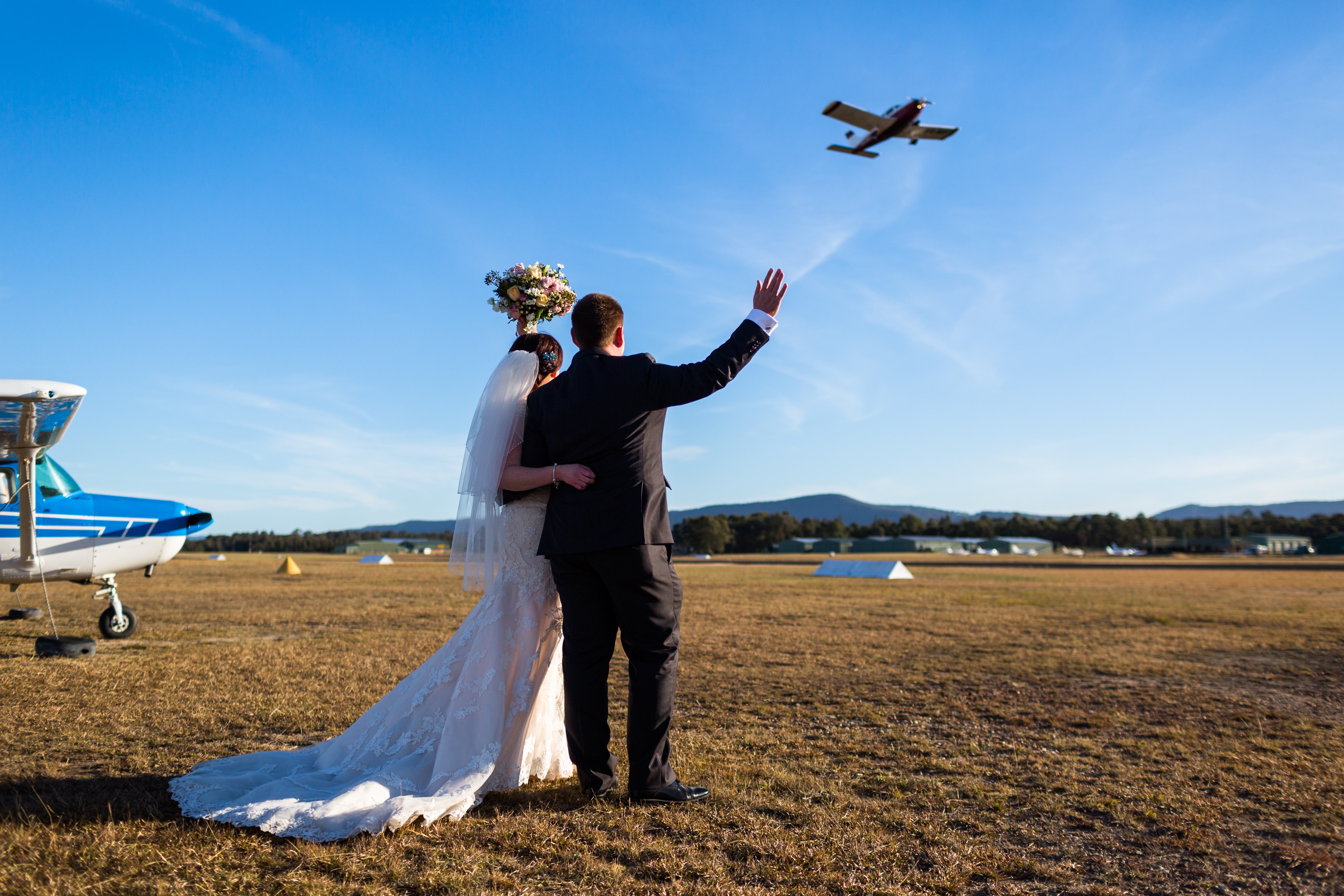 couple waving at an aeroplane